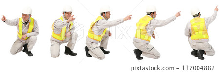 Full-body cutout of a man wearing helmet and work clothes in the factory or construction industry squatting 117004882