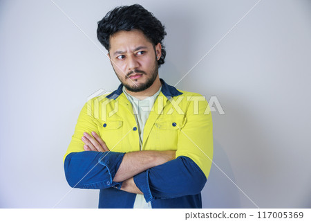 A man wearing yellow work clothes with his arms crossed A man wearing yellow work clothes with his arms crossed 117005369