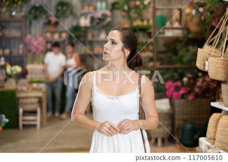 Focused brunette exploring furniture and accessories at garden store Focused brunette exploring furniture and accessories at garden store 117005610