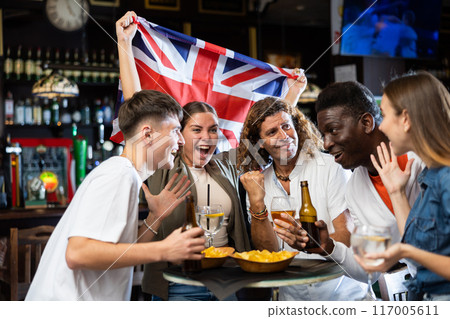 Group of football fans cheering for favorite British team in sports bar Group of football fans cheering for favorite British team in sports bar 117005611