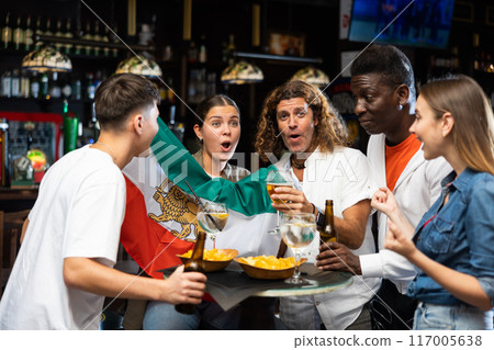 Excited sports fans celebrating victory of favorite Iranian team in bar Excited sports fans celebrating victory of favorite Iranian team in bar 117005638