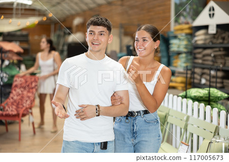 Married couple look for something in room garden furniture store, searching for item to complete patio. Woman with husband buyers looks around in showroom 117005673
