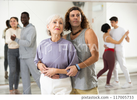 Positive adult man and smiling aged woman dancing in pair Positive adult man and smiling aged woman dancing in pair 117005733