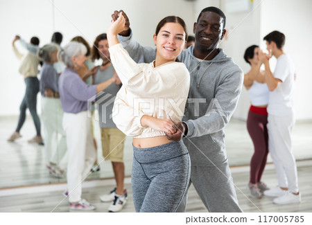 African man and caucasian lady rehearsing latin paired dance moves African man and caucasian lady rehearsing latin paired dance moves 117005785