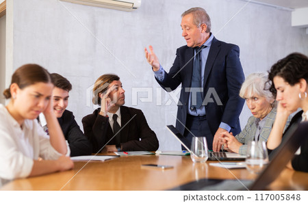 Portrait of angry male boss in business suit pointing to the door to his subordinate during meeting forcing him Portrait of angry male boss in business suit pointing to the door to his subordinate during meeting forcing him 117005848