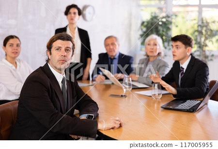 Woman and man sitting at table beside during meeting in conference room Woman and man sitting at table beside during meeting in conference room 117005955