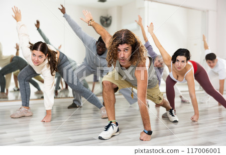 Group of active people performing a stretching exercise Group of active people performing a stretching exercise 117006001