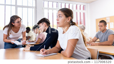 Young woman listening carefully to lecture in university Young woman listening carefully to lecture in university 117006320