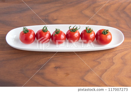 Medium tomatoes on a white plate 117007273