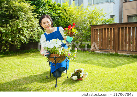 一位微笑的中年婦女正在種樹 一位微笑的中年婦女正在種樹 117007842