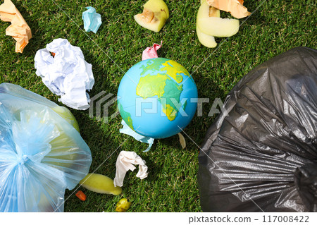 Garbage bags, garbage and globe on green background, top view 117008422