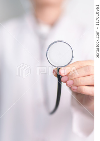 Healthcare and medical concept. doctor hand hold stethoscope in hospital. Health background, wellness and Insurance Healthcare and medical concept. doctor hand hold stethoscope in hospital. Health background, wellness and Insurance 117010961