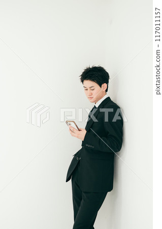 20多歲的英俊商人操作智慧型手機 117011157