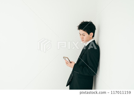 20多歲的英俊商人操作智慧型手機 117011159