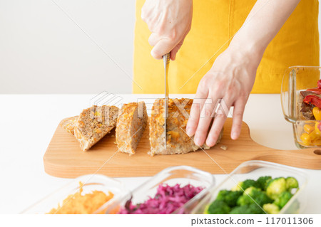 穿著黃色圍裙切肉餅的女人 117011306