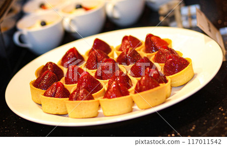 Beautiful multicolored decorated baked sweet tasty party cakes or catering cakes for party, bar dessert selection with cake, pie and pastries catering banquet, coffee break buffet at a conference 117011542