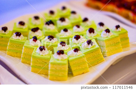 Beautiful multicolored decorated baked sweet tasty party cakes or catering cakes for party, bar dessert selection with cake, pie and pastries catering banquet, coffee break buffet at a conference 117011546