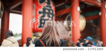 Tourist woman visit Sensoji Temple or Asakusa Kannon Temple is a Buddhist temple located in Asakusa, Tokyo Japan. Japanese sentence on red lantern means Thunder gate. 117011805