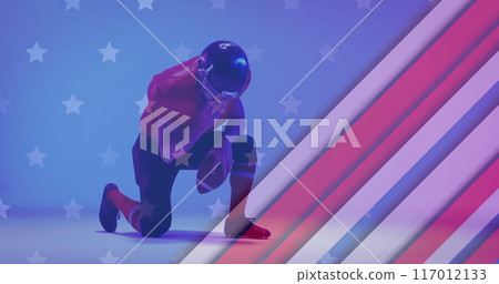 Image of caucasian american football player kneeling and flag of usa 117012133