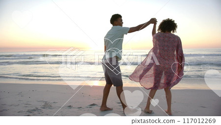 Image of hearts moving over diverse couple in love on beach in summer Image of hearts moving over diverse couple in love on beach in summer 117012269