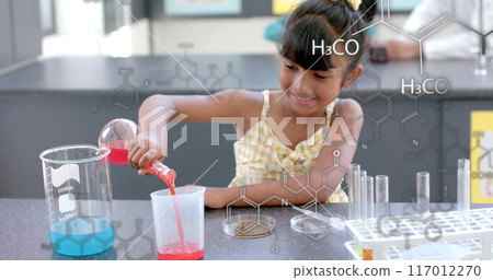Pouring red liquid into beaker, girl in lab with chemical formulas image 117012270