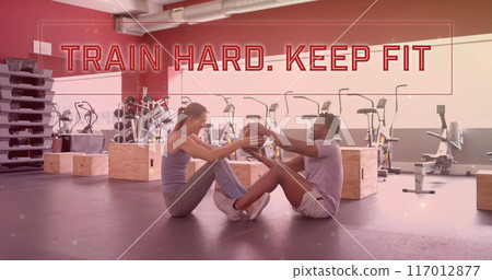 Image of train hard keep fit text over diverse man and woman exercising in gym Image of train hard keep fit text over diverse man and woman exercising in gym 117012877