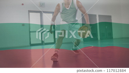 Image of flag of bulgaria over biracial male basketball player at gym 117012884