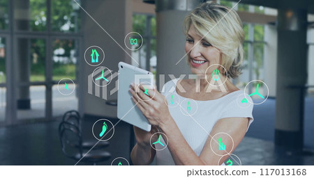 Image of ecology icons over caucasian businesswoman using tablet in office Image of ecology icons over caucasian businesswoman using tablet in office 117013168