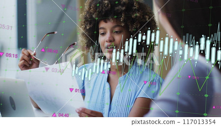 Image of graph processing data over biracial casual businesswoman talking to colleague at office Image of graph processing data over biracial casual businesswoman talking to colleague at office 117013354