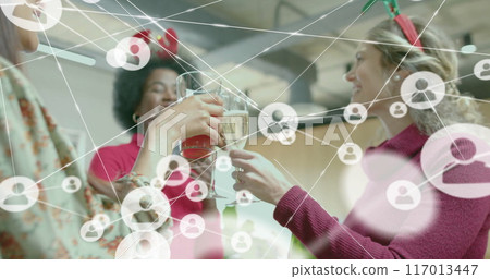 Image of network of connections with icons over diverse colleagues celebrating in office 117013447