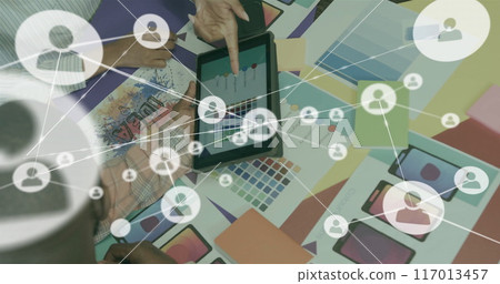 Image of network of connections with icons over diverse colleagues discussing project Image of network of connections with icons over diverse colleagues discussing project 117013457