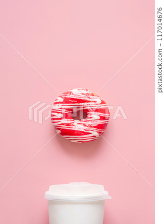 Pink frosted donut with white drizzle and white to go coffee cup. Breakfast or snack time concepts. 117014676