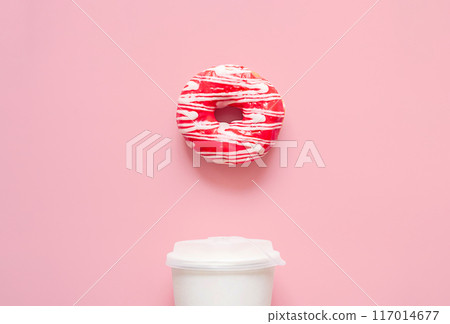 Pink frosted donut with white drizzle and white to go coffee cup. Breakfast or snack time concepts. 117014677