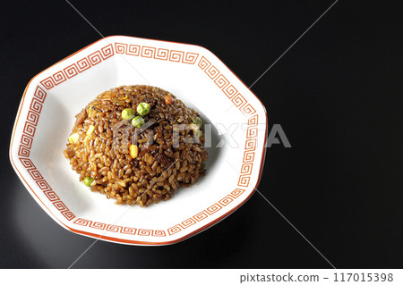 Burnt soy sauce fried rice photographed against a black background 117015398