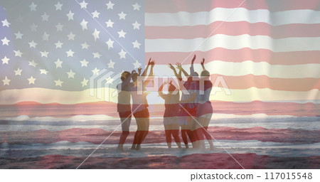 Image of american flag over diverse friends dancing on beach at sunset 117015548
