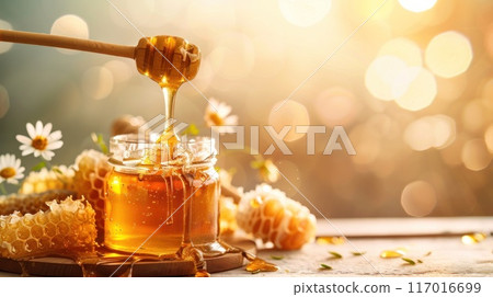 A jar of honey is poured into a glass 117016699