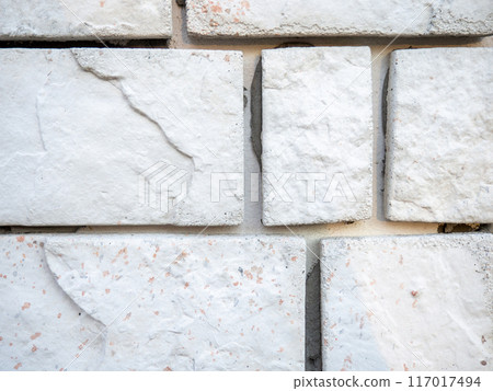 Abstraction on a white surface. Construction material. Stone tiles. Uneven surface.  Background of stones 117017494