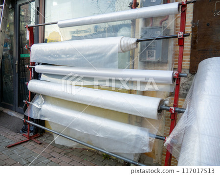 Trading shop for the sale of polyethylene. Rolls with polyethylene in assortment. Store goods on the street. 117017513