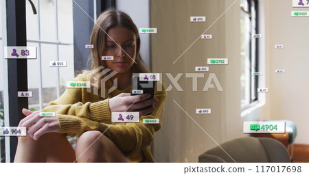Checking smartphone, woman surrounded by social media notifications and follower counts image 117017698