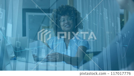 Financial data charts image over businesswoman working with documents in office 117017776