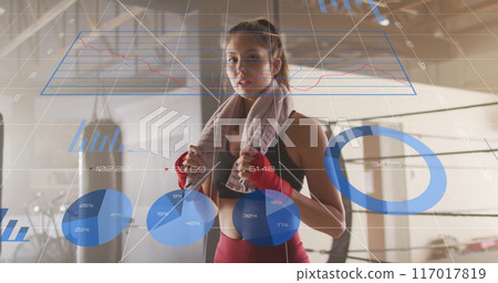 Fitness data visualization image over woman in gym with towel and boxing gloves 117017819