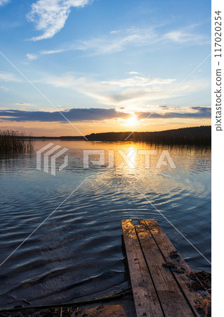 Vertical landscape photo with colorful sunset clouds over still lake 117020254