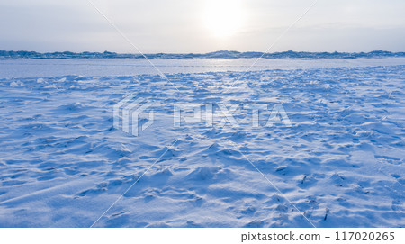 Winter landscape with ice of frozen Baltic sea under blue sky 117020265