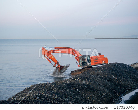 Excavator work at night. Overtime work. The work of construction equipment on the seashore. Batumi. Fortified shores. at sunset. Hitachi 117020346