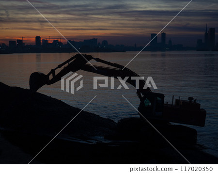 Excavator work at night. Overtime work. The work of construction equipment on the seashore. Batumi. Fortified shores. Excavator work at night. Overtime work. The work of construction equipment on the seashore. Batumi. Fortified shores. 117020350