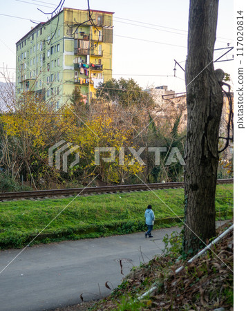 Man on the alley in the autumn park. The streets of the city. Winter landscape of the southern city. Outskirts of the city of Batumi. Man on the street. Winter at the resort. 117020814