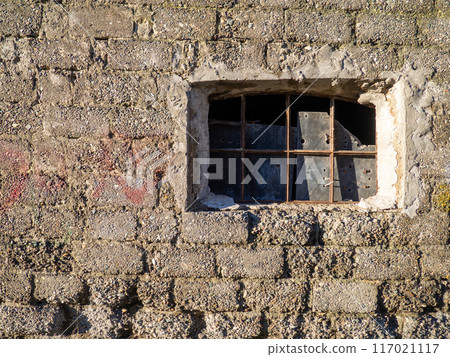 Window in a destroyed building. Remained a wall from the house. The concept of demolition of dilapidated housing. Window in a destroyed building. Remained a wall from the house. The concept of demolition of dilapidated housing. 117021117