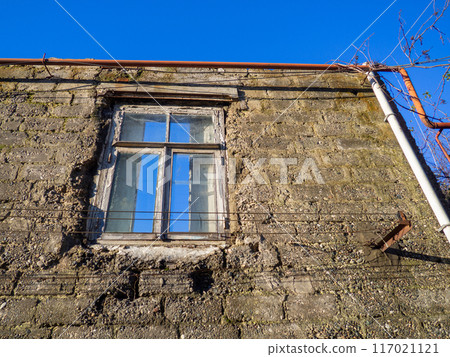 Window in a destroyed building. Remained a wall from the house. The concept of demolition of dilapidated housing. 117021121