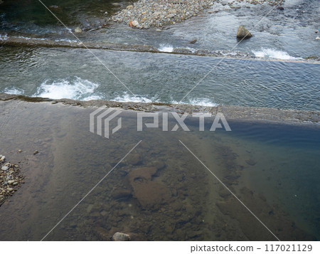 A shallow fast river. Stream with shallows. Concrete rapids on the river A shallow fast river. Stream with shallows. Concrete rapids on the river 117021129