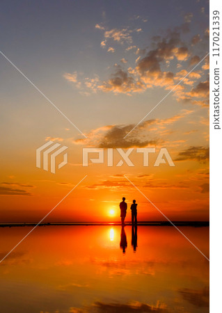 Silhouettes of people against sky seascape sunset sky on sea or ocean Silhouettes of people against sky seascape sunset sky on sea or ocean 117021339